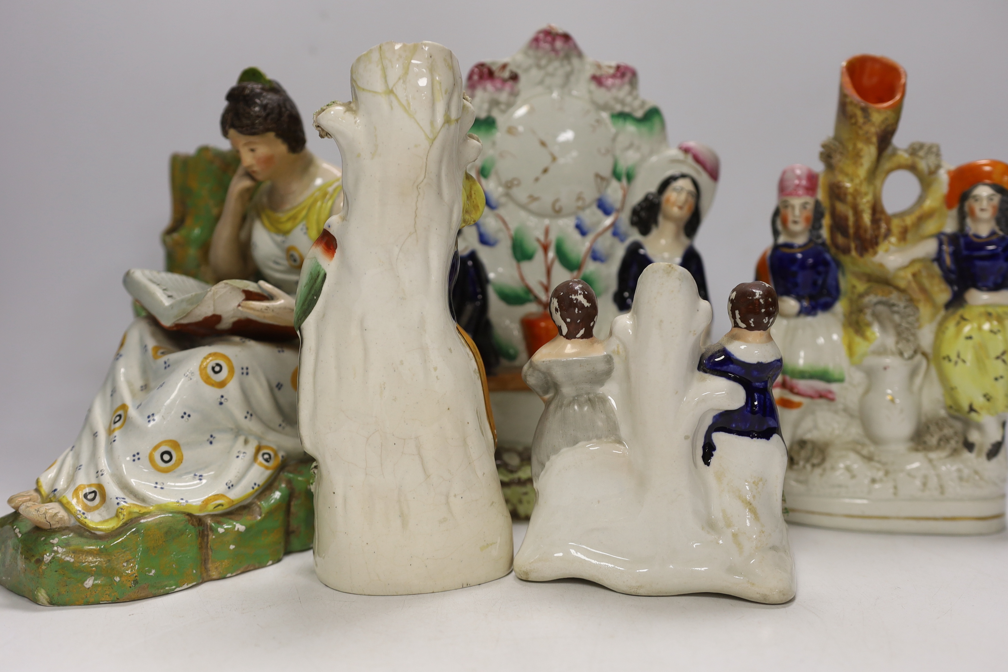 An early 19th century Staffordshire pearlware figure of a seated lady and seven mid 19th century Staffordshire pottery figures